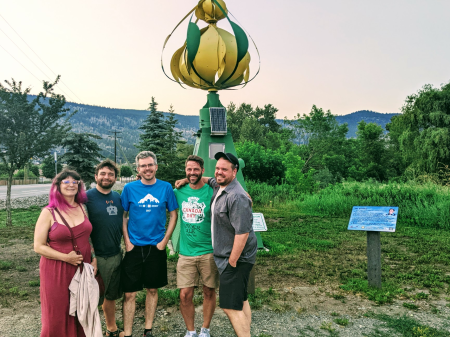 Group photo infront of a metal flower